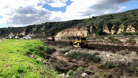 Bulldozers-grading-in-a-river-bed-after-a-storm-washed-out-the-road-Angle-1