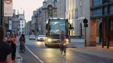 A-modern-bus-rides-along-a-busy-beautiful-street,-twilight