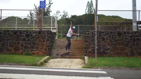 person-jumps-down-a-tall-stair-set-on-their-skateboard