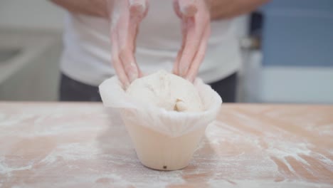 Closeup-of-hands-of-a-baker,-making-a-bread-loaf-out-of-dough-in-a-form