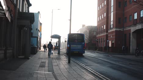 A-bus-pulling-away-from-a-town-centre-bus-stop-after-picking-up-a-passenger