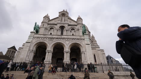 Moving-low-angled-shot-facing-the-facade-of-the-Sacre-Coeur-Basilica-on-cloudy-winter's-day