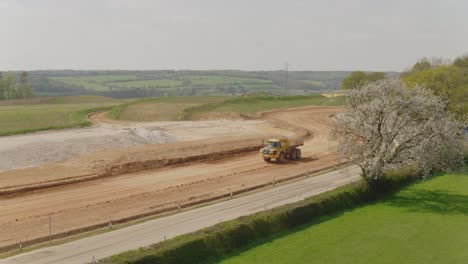 A-dump-truck-makes-its-way-at-speed-along-a-construction-site-track