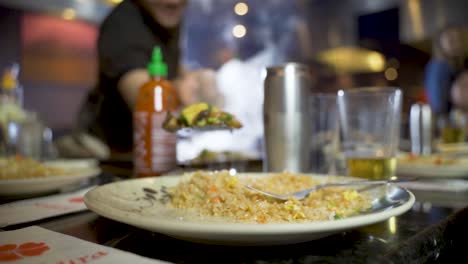 Traditional-teppanyaki-fried-rice-with-vegetables-being-served-by-chef,-closeup