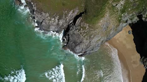 Beach-Cove-in-Cornwall-from-an-Aerial-Top-Down-View-Over-Ocean-Waves-and-Cliffs,-UK