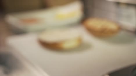 Close-up-and-slow-motion-of-hand-adding-arugula-to-burger-bread