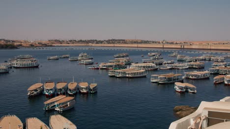 boat-moored-at-bay-in-Aswan-Dam-and-Lake-Nasser,-Egypt-carrying-tourist-to-visit-the-Philae-temple-complex-island-travel-destination