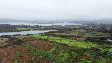 Luftaufnahme-Von-Grünem-Grasland-Zwischen-Nebligen-Seen-Im-Wunderschönen-Irland