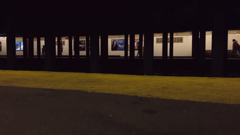 Subway-platform-with-commuters-and-ads-on-23-street-platform