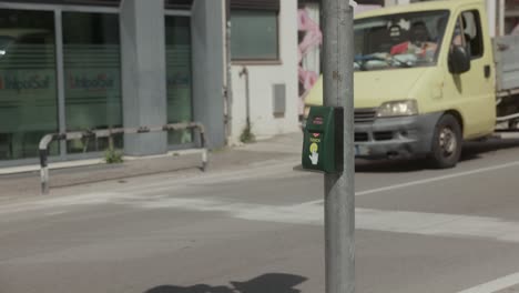 Pedestrian-Pushes-Traffic-Button-Before-Crossing-Street-In-Italy