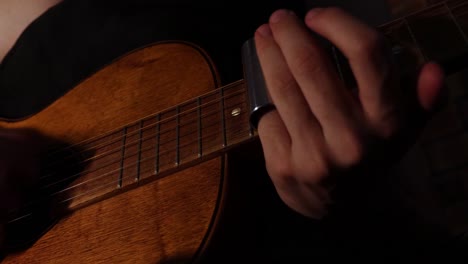 Musician-playing-antique-parlor-slide-guitar-close-up