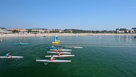 Kinder-Mit-Rettungswesten-Konkurrieren-In-Rudern-Kanu-Rennen-Auf-Der-Vorbereiteten-Strecke-Am-Strand-Des-Touristen--Und-Feriendorfes-Ein-Sonniger-Morgen,-Schießen-Tracking