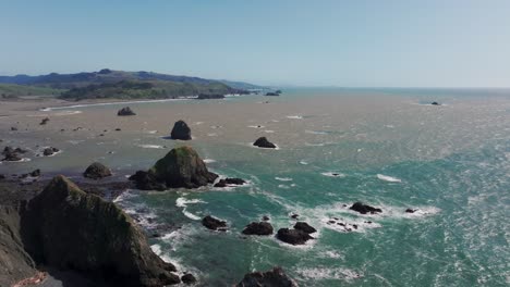 Drone-shot-panning-over-the-pacific-northwest-coastline-on-a-sunny-day