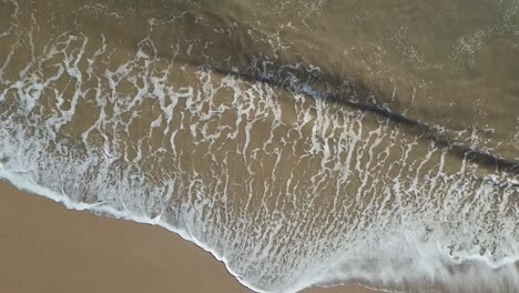 Aerial-Top-Down-Over-Beach-in-Cornwall-with-Ocean-Waves-in-Slow-Motion