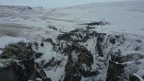 Isländische-Landschaft-Bedeckt-Mit-Schnee-Und-Eis-In-Einer-Felsformation-Gorje,-Luftaufnahme-Einer-Drohne,-Island