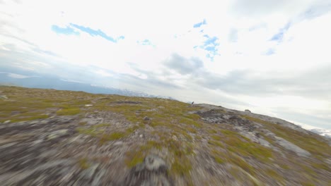 Dynamischer-FPV-Flug-Auf-Dem-Gipfel-Des-Rossnos-Gebirges-In-Norwegen-Mit-Männlichem-Wanderer,-Der-Sein-Ziel-Erreicht