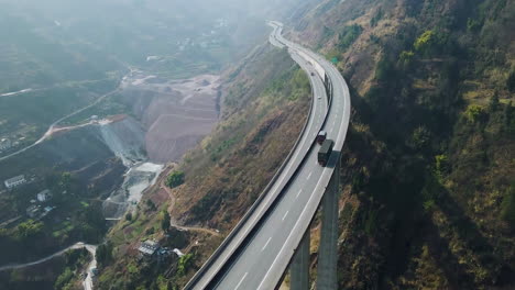 Side-View-Of-Trucks-Cars-Vehicles-Passing-Double-Lane-Highway-Bridge-In-The-Mountains-Motorway
