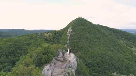 Luftaufnahme-Eines-Hochzeitspaares,-Das-Sich-Auf-Dem-Gipfel-Eines-Berges-In-Kroatien-Küsst