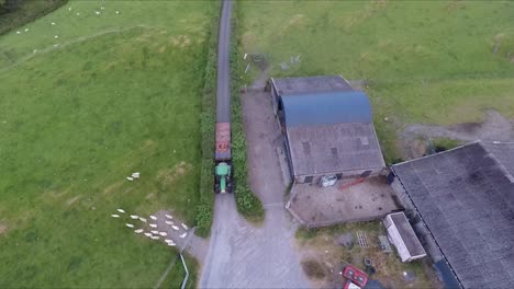 Granja-De-Ovejas-Machynlleth-En-Gales-Con-Video-De-Drones-Moviéndose-Sobre-La-Conducción-De-Un-Tractor