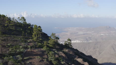 Cinematic-fly-over-of-mountains-peak-which-reveals-a-panoramic-view-above-the-mountainious-landscape-and-the-coastline-of-Gran-Canaria