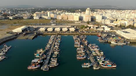 Dock-Mit-Kleinen-Fischerbooten-Vor-Anker-In-Der-Stadt-Quarteira,-Algarve