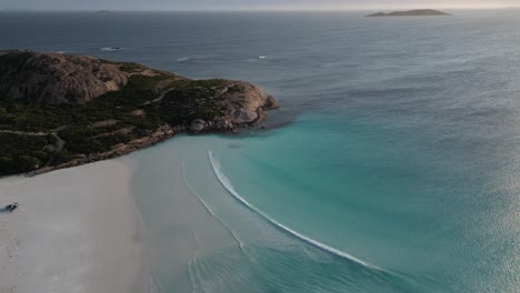 Aerial-top-down-of-empty-sandy-beach-with-turquoise-water-of-bay-during-sunset-time