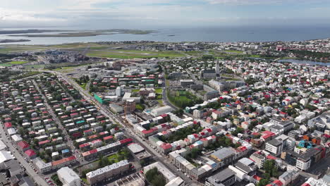 Flying-Above-Reykjavik-Iceland,-Aerial-View-of-Downtown-Buildings,-Church-and-Streets