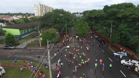 Aerial-drone-shot-of-children-competing-in-a-real-marathon-with-lots-of-people