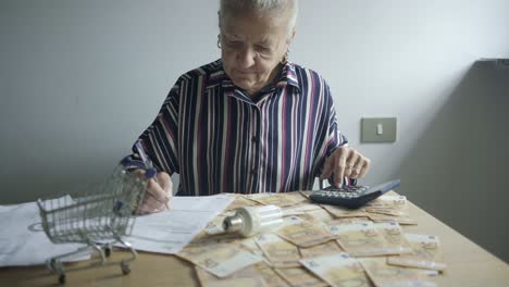 senior-woman-check-bills-pay-utility-with-euro-and-bulb-lamp-saving-money-calculation-on-desktop-at-home