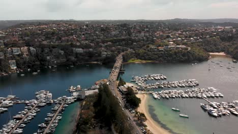 Drone-panoramic-view-stationary-over-marina-area-with-roads-showing-traffic-flowing-in-Sydney,-Australia