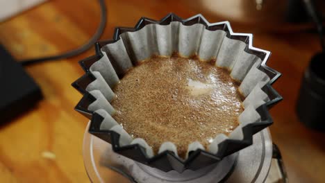 Manually-pouring-pot-hot-water-over-coffee-filter-in-slow-motion