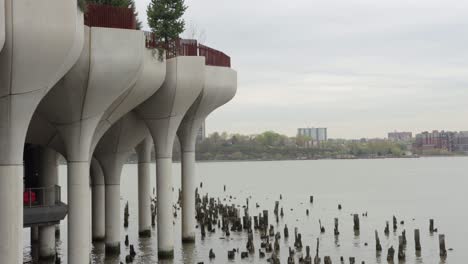 The-Jersey-City-Coastline-on-the-Hudson-River-with-Little-Island-Park-and-Old-Pier-Supports-in-the-Foreground-on-a-Cloudy-Day