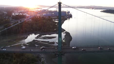 4K-Luftaufnahmen-Der-Lions-Gate-Bridge-Am-Morgen-Mit-Blick-Auf-Vancouver-Und-Stanley-Park,-Abgesperrte-Position-Mit-Sonne-Im-Hintergrund