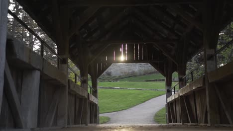 Cullen-Gardens-Central-Park-Footbridge-with-Sunlight-Beaming-Through-the-Wooden-Roof-in-Whitby,-Canada