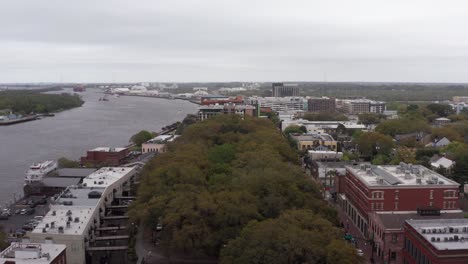 Low-close-up-aerial-shot-of-Emmet-Park-along-the-river-in-downtown-Savannah,-Georgia