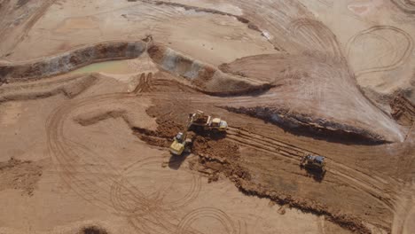 Wide-drone-construction-site-footage-of-a-digger,-dump-truck-and-bulldozer-working