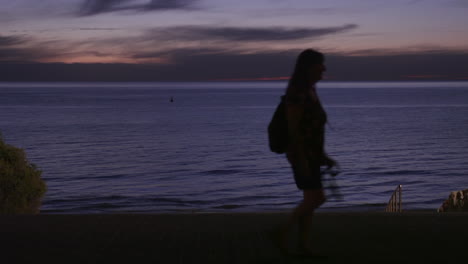 El-Océano-Y-La-Playa-Justo-Después-Del-Atardecer-Con-Gente-Caminando-Recortada-Por-Los-Hermosos-Cielos-Brillantes