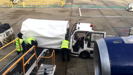 View-from-Aircraft-of-Gatwick-Ground-Crew-securing-cover,-Handheld-Medium-Shot