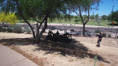 Piloto-De-Drones-Filmando-El-Torneo-De-Golf-Folds-Of-Honor-Aterriza-Su-Dron-Junto-Al-Camino-De-Su-Carrito-De-Golf,-Westin-Kierland-Resort,-Scottsdale,-Arizona