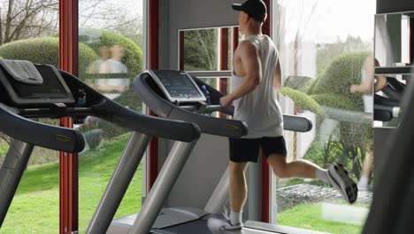 Fitness-motivation-as-male-run-on-treadmill-and-do-cardio-exercise,-indoor-gym