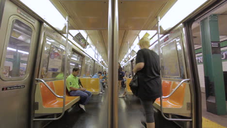 Menschen-Steigen-In-New-York-City-In-Eine-U-Bahn-Ein-Und-Aus,-Wenn-Diese-Den-Bahnhof-Verlässt