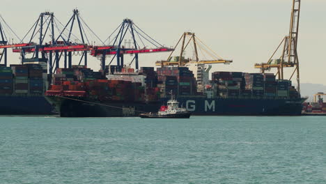 Remolcadores-Que-Transportan-Un-Buque-De-Carga-Lleno-De-Contenedores-Para-Salir-Del-Puerto-De-Valencia,-España