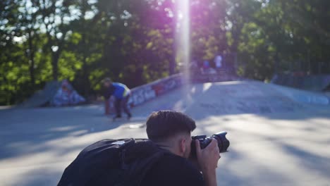 Photographer-crouching-down-to-take-a-photograph-in-a-skatepark