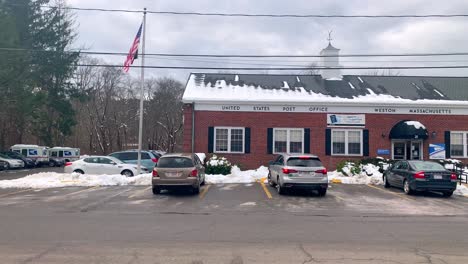 United-States-Post-Office-in-winter-covered-in-snow-in-the-New-England-area-with-the-American-flag