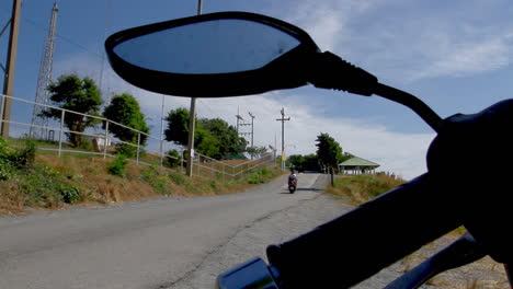 pov-of-feeder-road-to-Promthep-Cape-Viewpoint-in-Rawai,-Phuket,-Thailand-shot-behind-a-motorcycle-handlebar