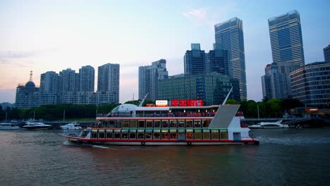 A-sightseeing-tour-boat-traversing-the-Huangpu-River-in-the-evening-in-China's-major-city-of-Shanghai