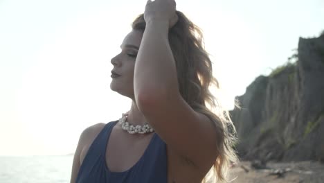 A-Girl-Taking-A-Pose-While-Fixing-Her-Blonde-Hair-And-Looking-Through-The-Place-With-Background-Of-Cliffs-And-Bright-Sky-In-Ontario,-Canada---Close-Up-Shot