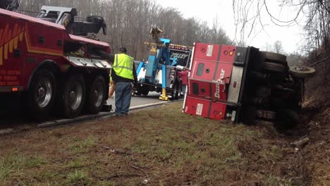 Wrecker-team-pulling-armored-car-from-ditch-after-wrecking-on-busy-highway
