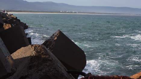 Große-Wellen-Brechen-Gegen-Steinblöcke,-Die-An-Der-Küste-Wellenstopper-Verursachen