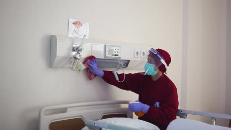 Un-Trabajador-Está-Limpiando-Alrededor-De-La-Cama-De-Un-Paciente-En-Un-Hospital